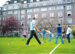 Club members playing GB on the lawn in the center of the collegefs main building.